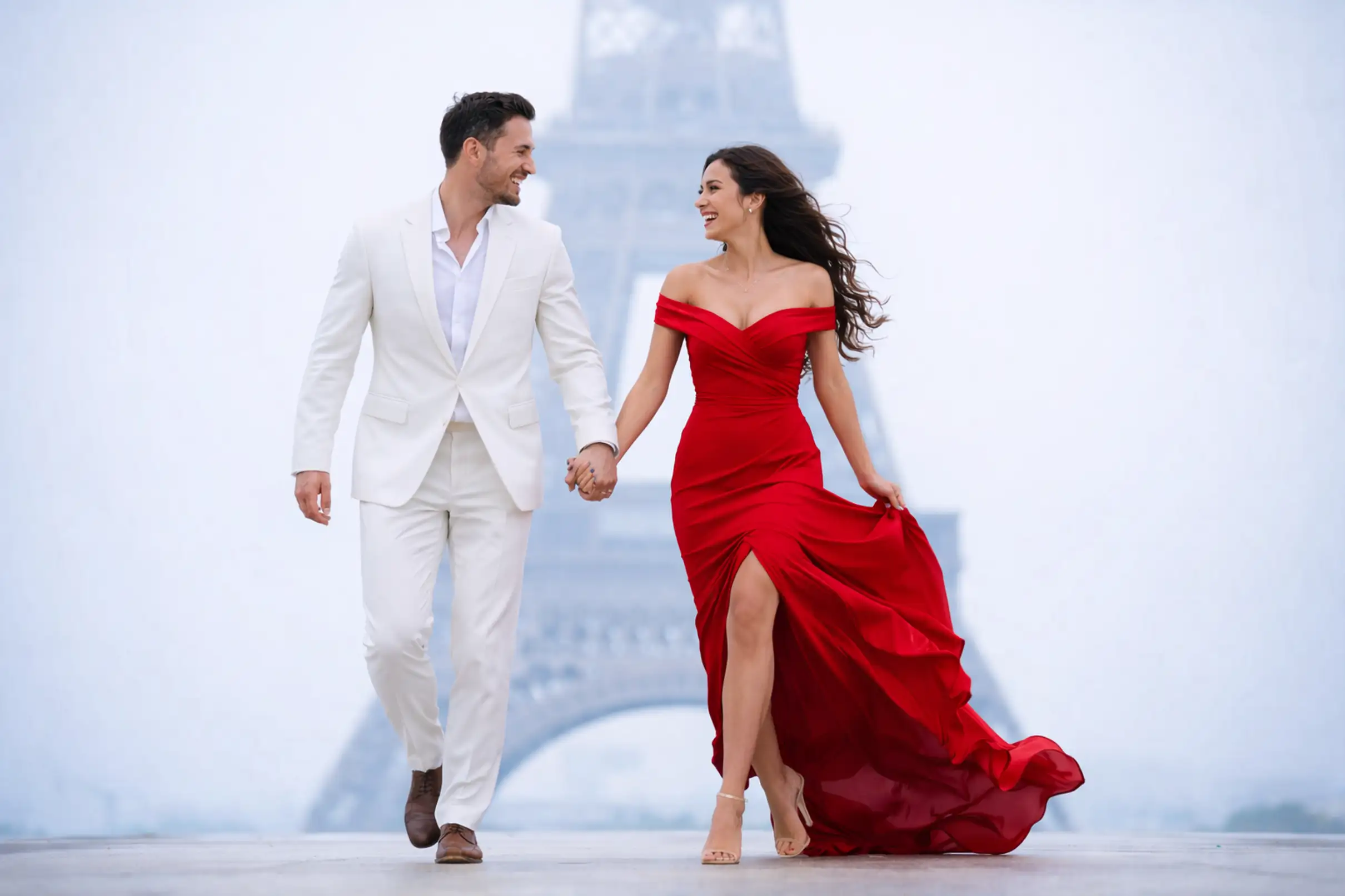 Couple marchant main dans la main devant la tour Eiffel, robe rouge
