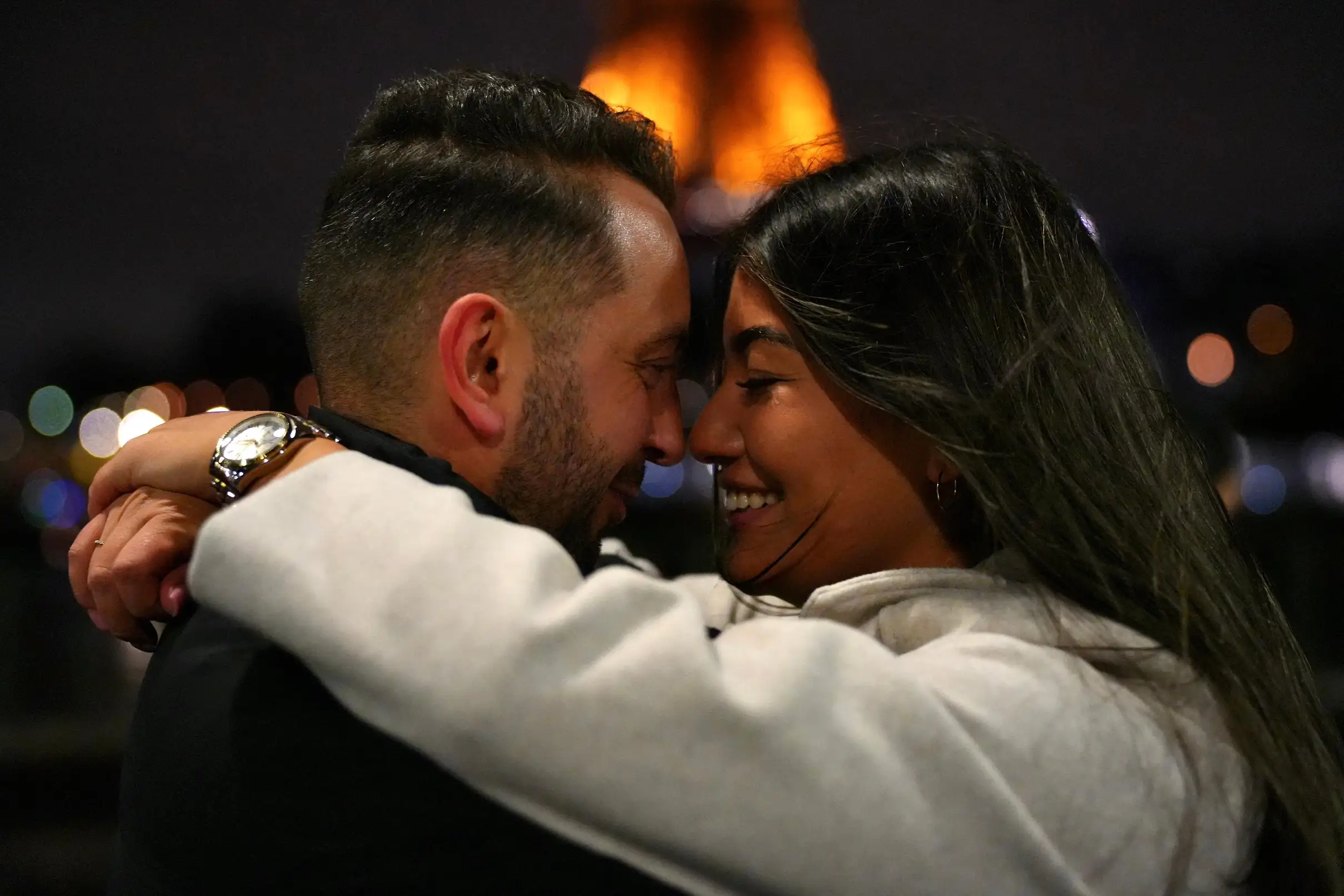 Couple enlacé le soir devant la tour Eiffel illuminée